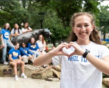 A student shows her love while her classmates pose around the Panther statue.